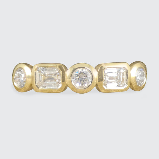 Half eternity ring with alternating emerald-cut and brilliant-cut diamonds, bezel set in 18ct yellow gold, offering a modern and sophisticated design.