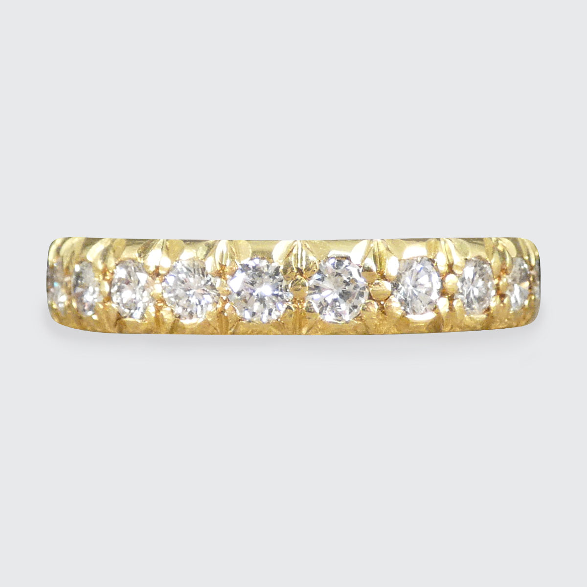 Full eternity band crafted in 18ct yellow gold, featuring bright and clear diamonds totalling 1.33ct set around the entire band with intricate detailing.