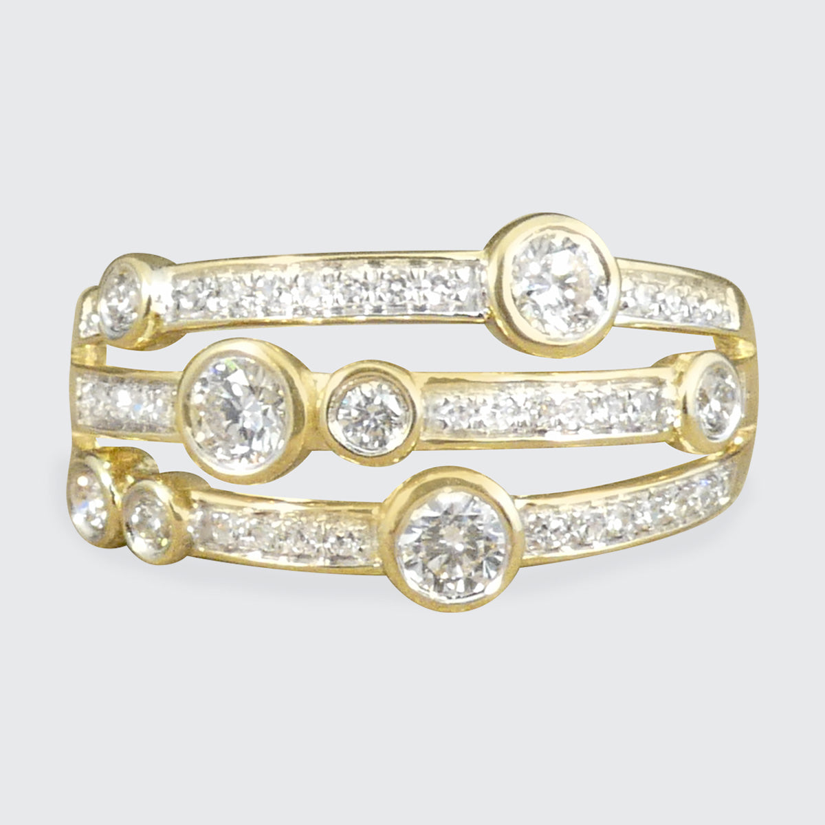 A modern bubble style diamond set ring. With larger and smaller Diamonds bezel set into three bands across a the head of the ring. A great gift idea and statement ring. All fully made in 9ct Yellow Gold with a warm beautiful aesthetic. 