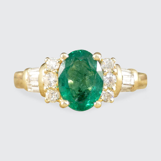 An Emerald and Diamond ring with staged shoulders in 14ct Yellow Gold