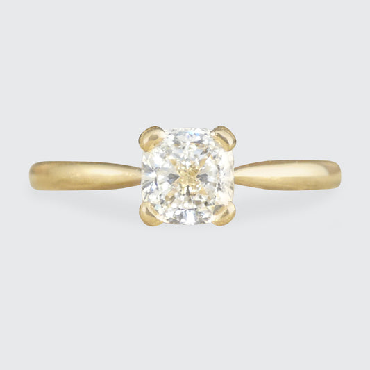 18 carat yellow gold ring featuring a GIA-certified modified cushion-cut diamond of exceptional E colour. The elegant solitaire design highlights the diamond's brilliance and clarity, creating a timeless and sophisticated engagement ring.