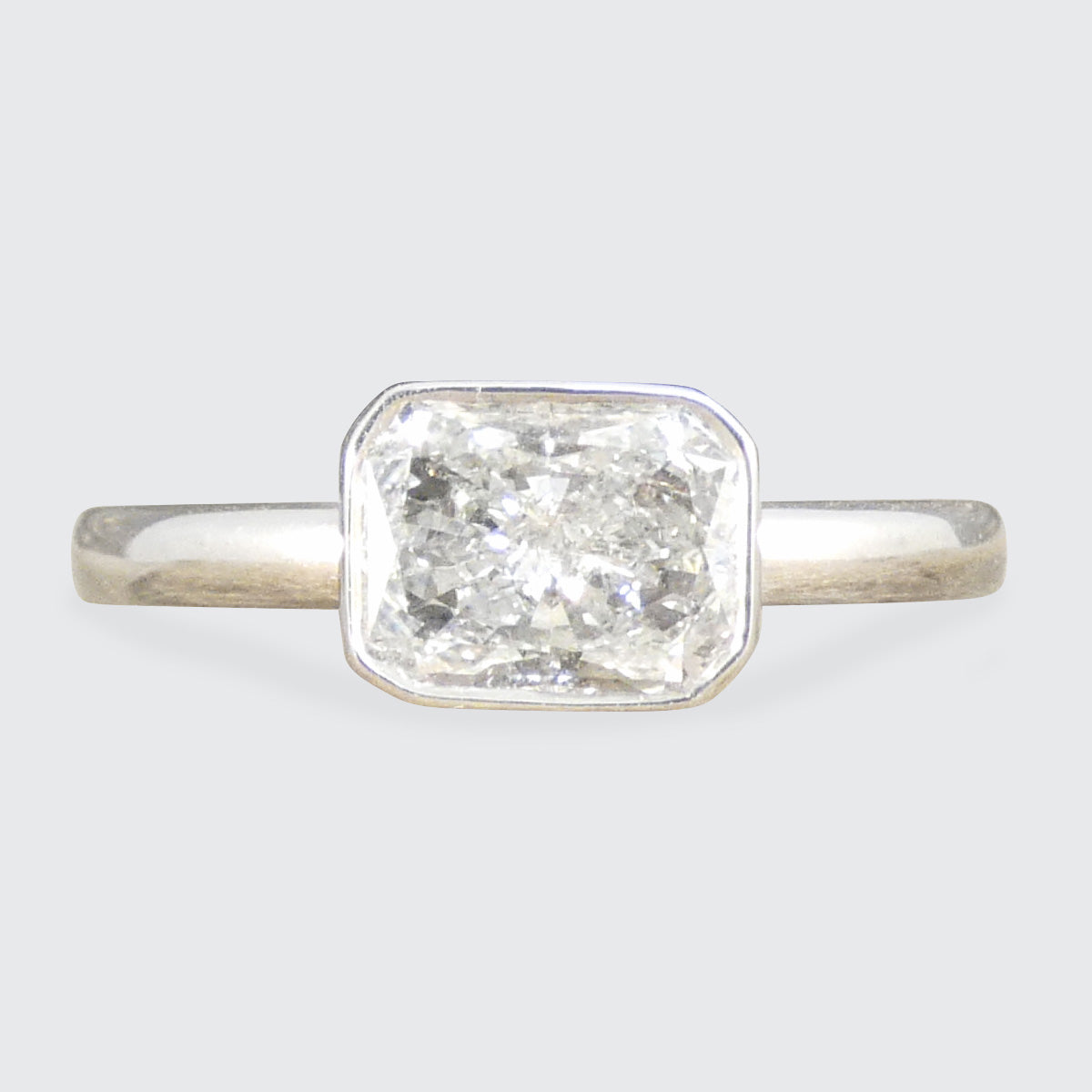 Radiant cut bezel set solitaire diamond ring crafted in 18ct white gold, showcasing a brilliant and modern design.