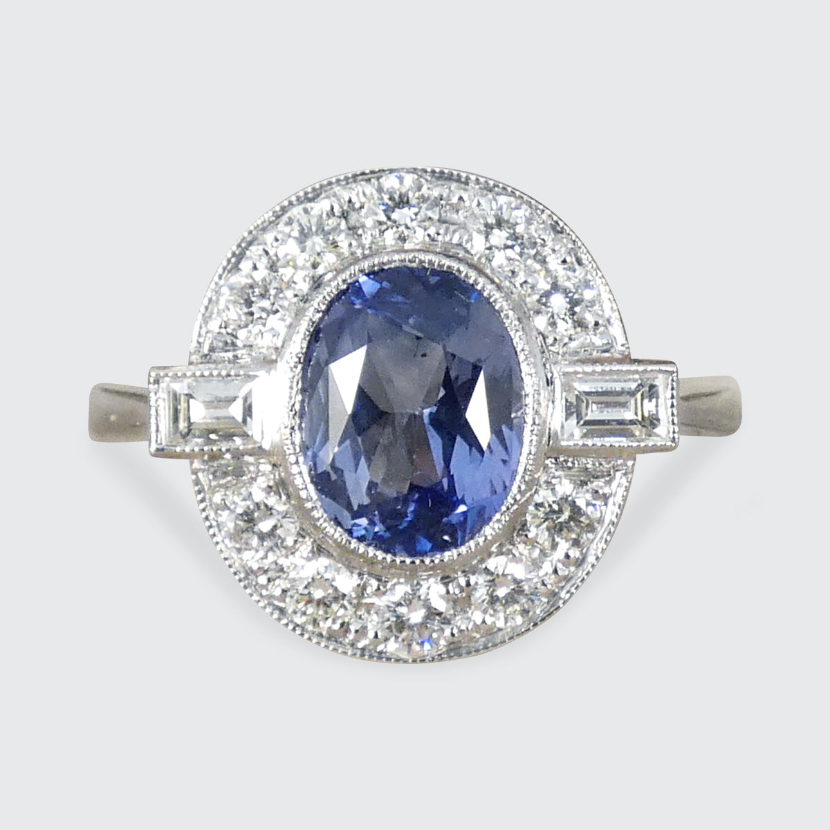 Art Deco style Sapphire and Diamond cluster ring in Platinum with equally matched stones.