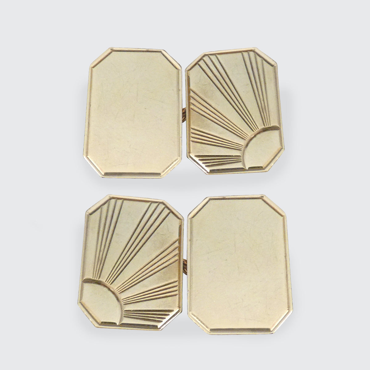 Pair of vintage gold-tone cufflinks featuring an elegant Art Deco-inspired sunburst design. The octagonal shape and intricate engraved detailing make these cufflinks a timeless accessory for formal occasions or a thoughtful gift.