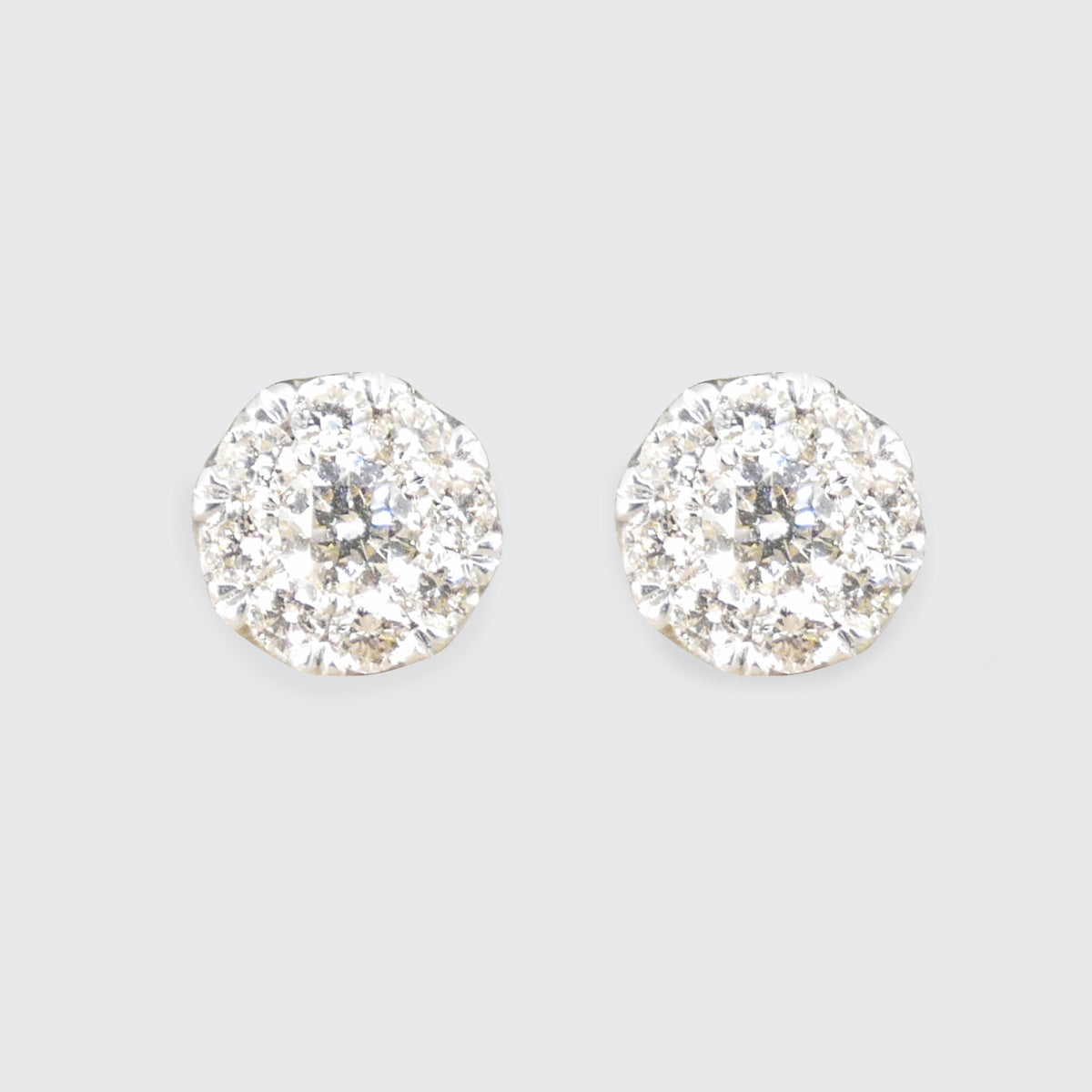 Dazzling diamond illusion cluster earrings in white gold, designed to appear as a single larger stone with intricate brilliance.