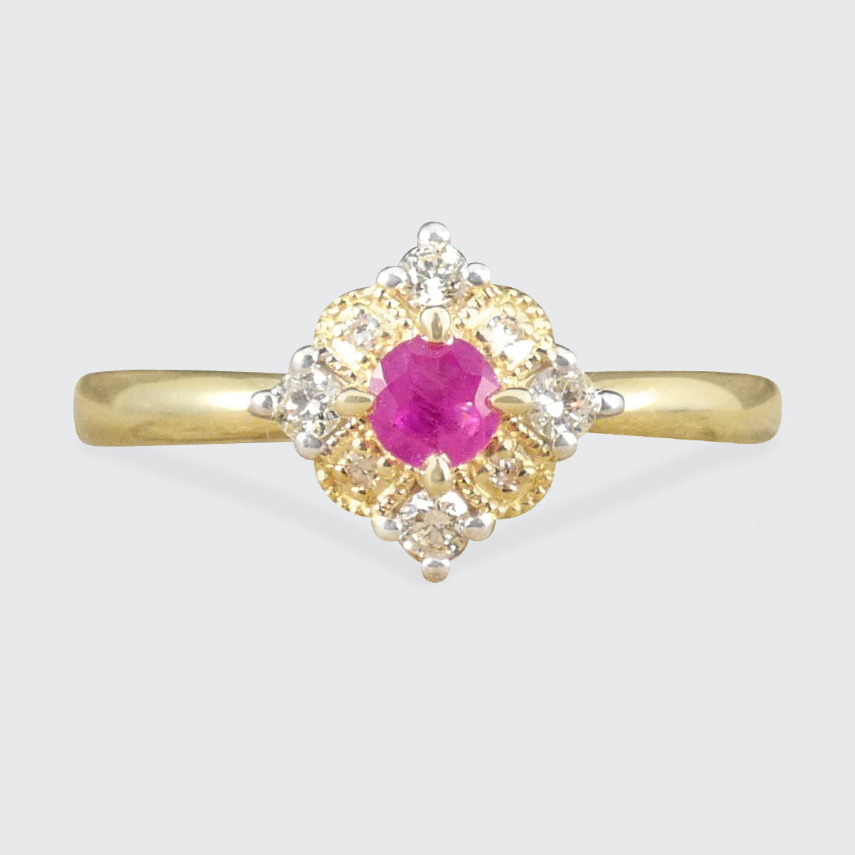 Ruby and Diamond Cross Section Illusion Set Ring in Yellow and White Gold showing a bright pink hue in the ruby and a gold cluster ring with a difference.