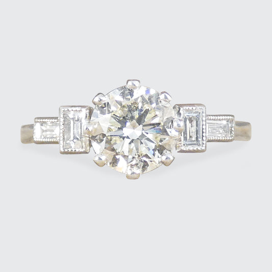 Art Deco homage engagement ring with an early brilliant cut centre and baguette cut diamond shoulders set in Platinum.