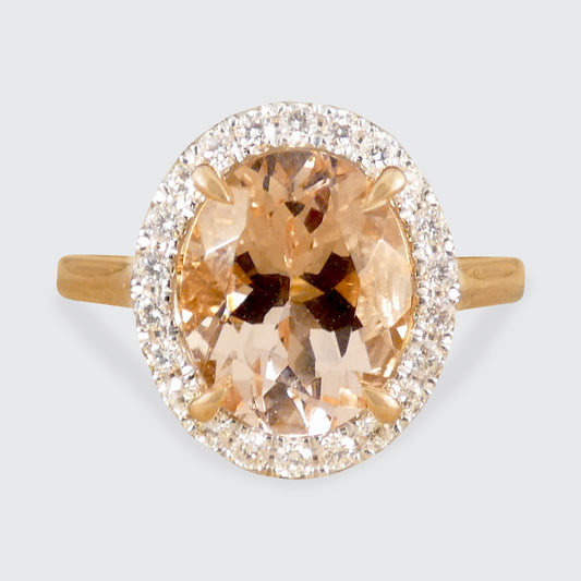 2.51ct Oval Cut Morganite and Diamond Halo cluster ring in 18ct White and Rose gold. The Morganite is showing a lovely peachy pink hue with a four spiked claw setting.