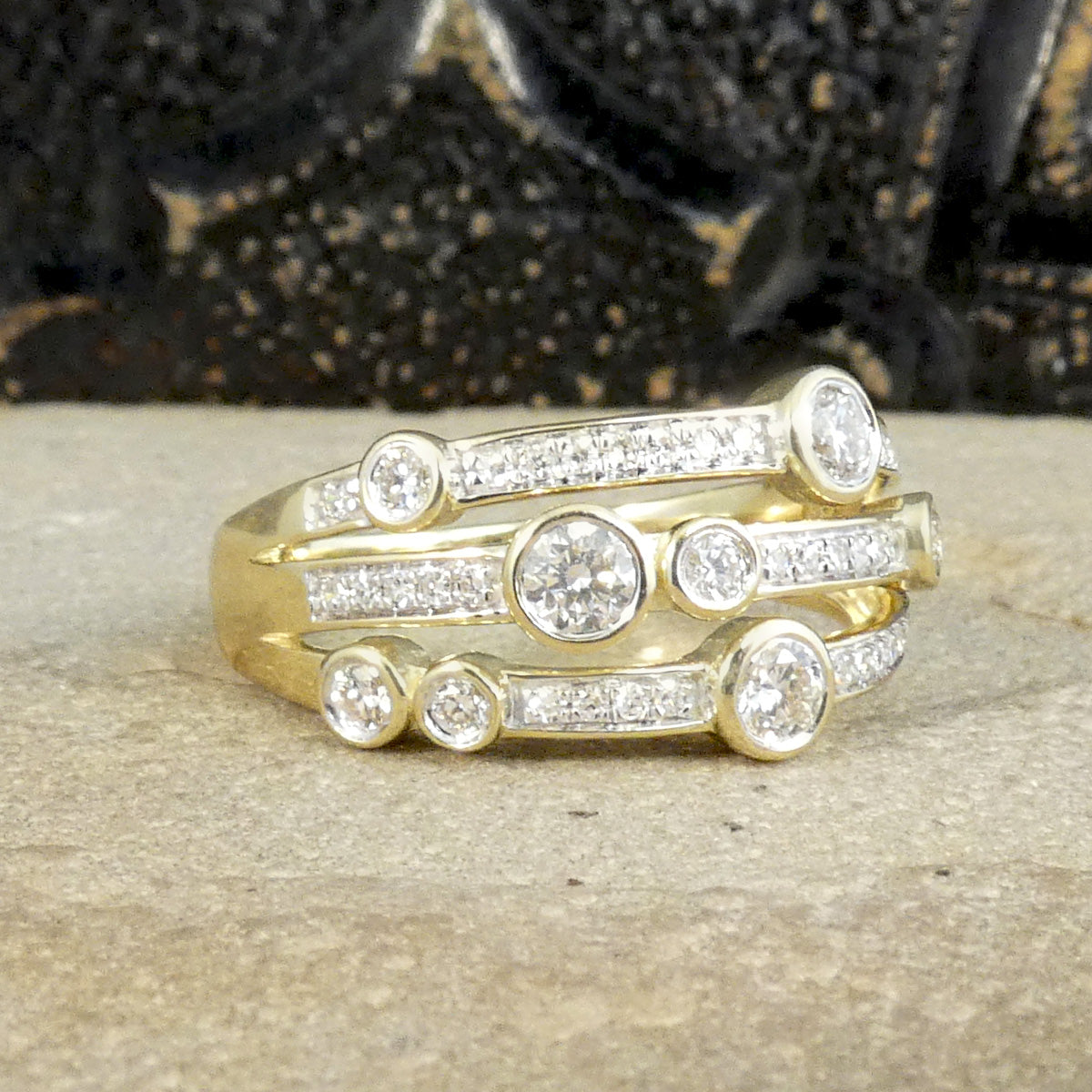 A modern bubble style diamond set ring. With larger and smaller Diamonds bezel set into three bands across a the head of the ring. A great gift idea and statement ring. All fully made in 9ct Yellow Gold with a warm beautiful aesthetic. 