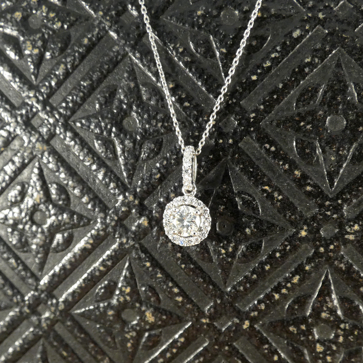 Elegant diamond halo cluster necklace in platinum, featuring a dazzling central diamond surrounded by a halo of sparkling stones, suspended from a delicate chain—an ideal gift for any special occasion.