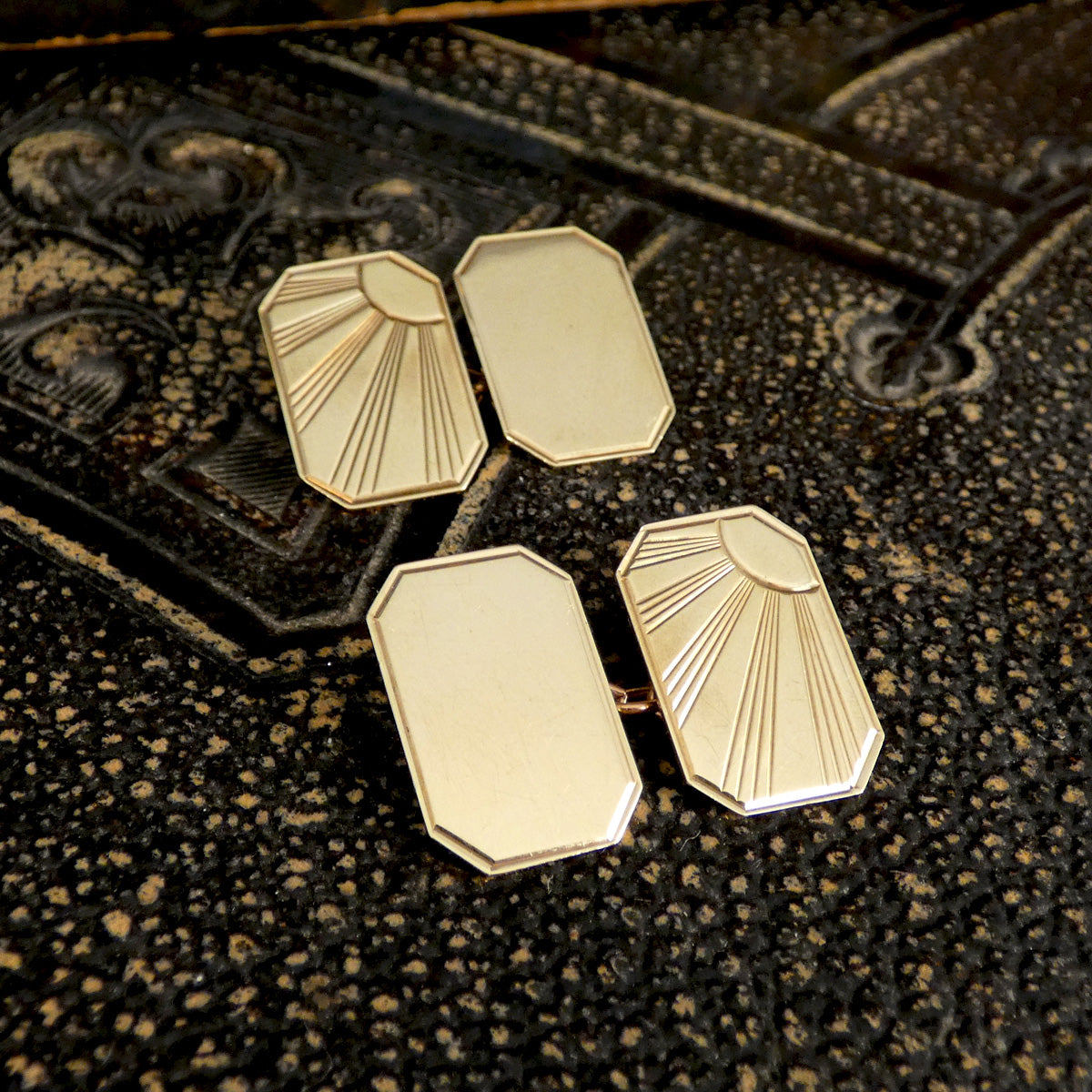 Stunning pair of vintage cufflinks in gold-tone with a sleek Art Deco sunburst motif. The intricate engraving contrasts beautifully with the polished blank panels, offering a sophisticated and versatile design for any formal attire.