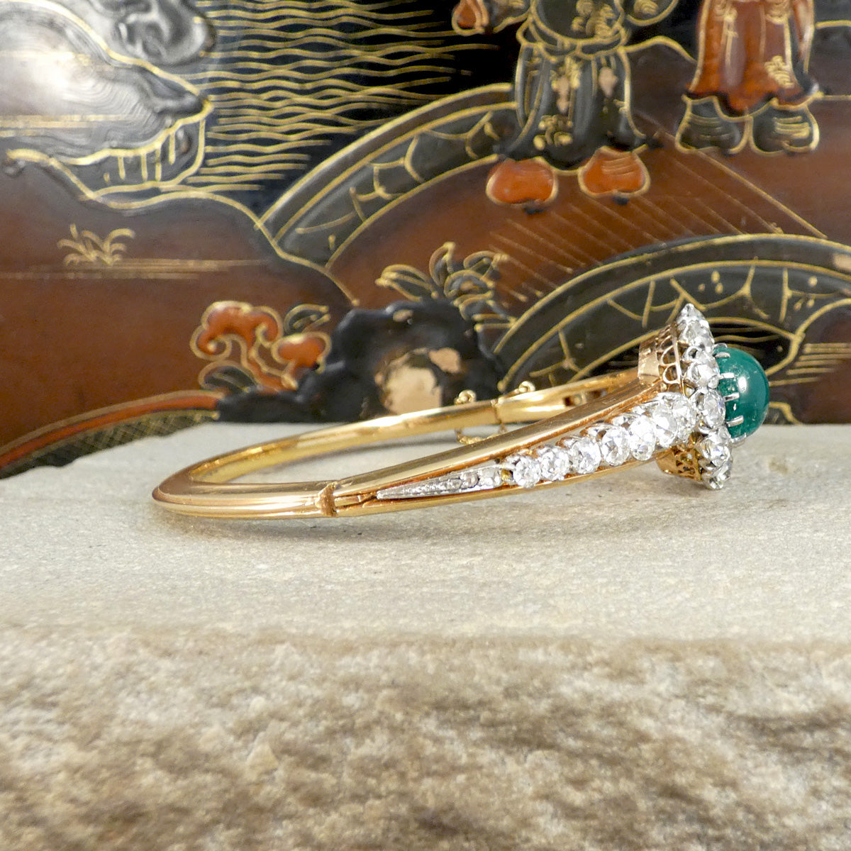 Side profile view of the late Victorian cabochon emerald and diamond bangle, highlighting the elegant tapering design with old-cut diamonds set in yellow gold and intricate under-gallery details.