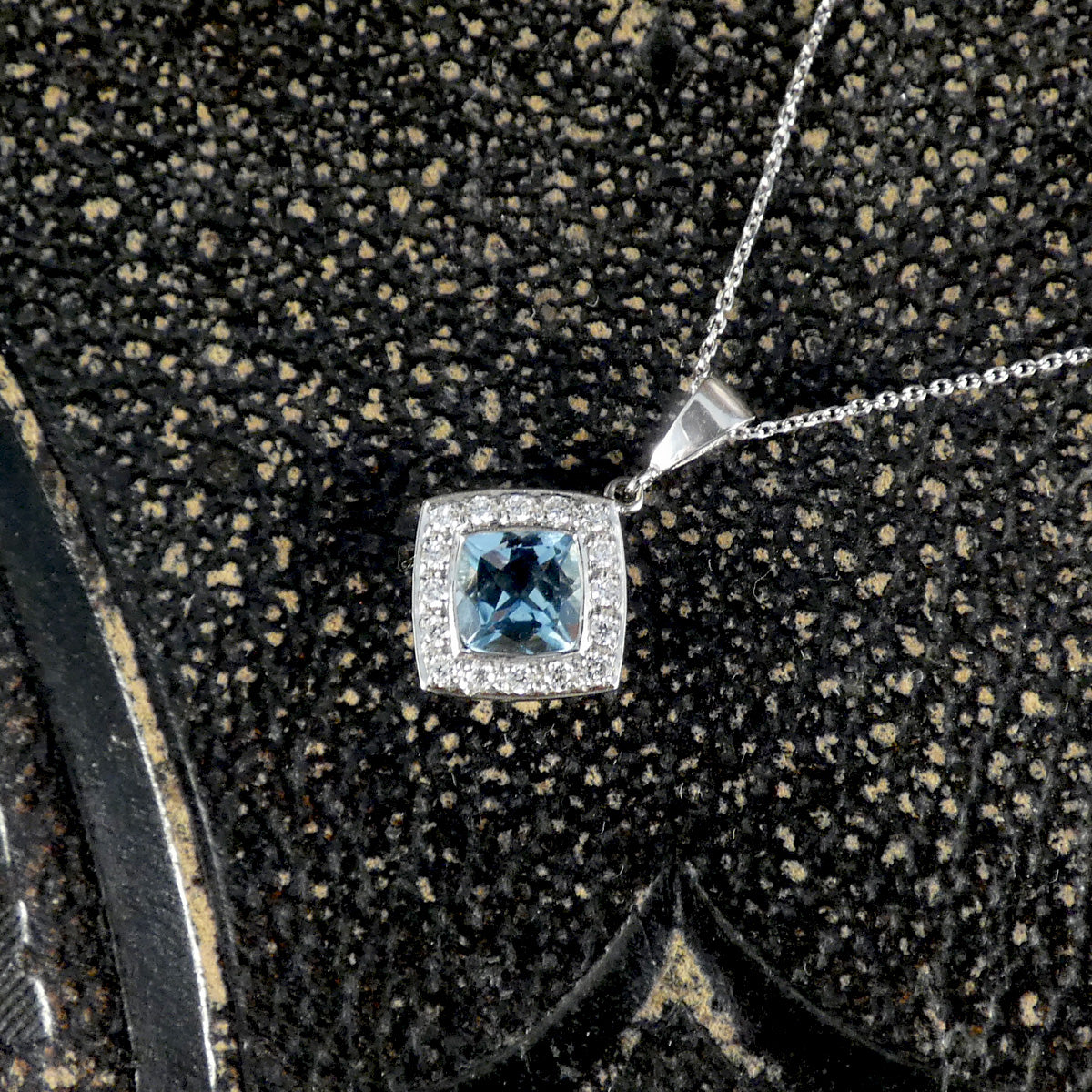 Close up of strong blue Aquamarine and Diamond Cluster Pendant Necklace in Platinum with a solid platinum bail on a trace chain.