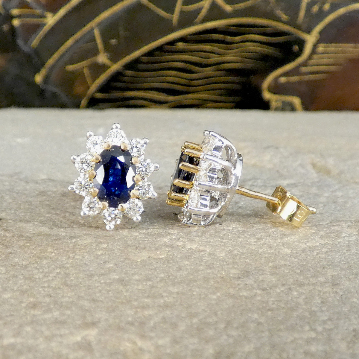 Classic Sapphire and Diamond cluster stud earrings in 18ct Yellow and White Gold. Showing a deep and mesmerising blue hue, with a yellow gold stem and butterfly back.