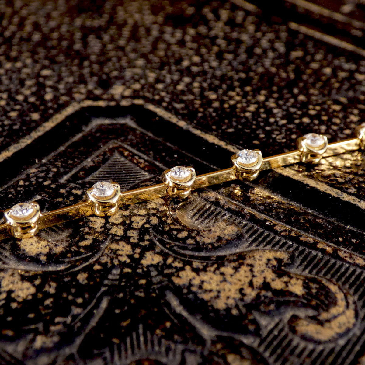 Close-up view of an 18ct yellow gold diamond bracelet showcasing rose basket bezel-set brilliant-cut diamonds, highlighting their sparkle and elegant craftsmanship.