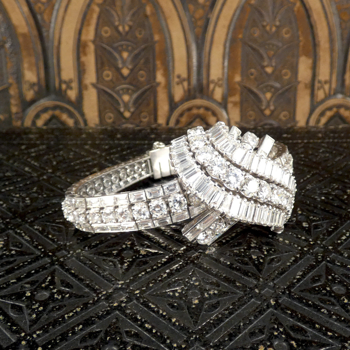 Side view of a stunning 1950's French diamond bracelet, featuring intricate detailing with approximately 30 carats of round and baguette-cut diamonds in a luxurious platinum setting.