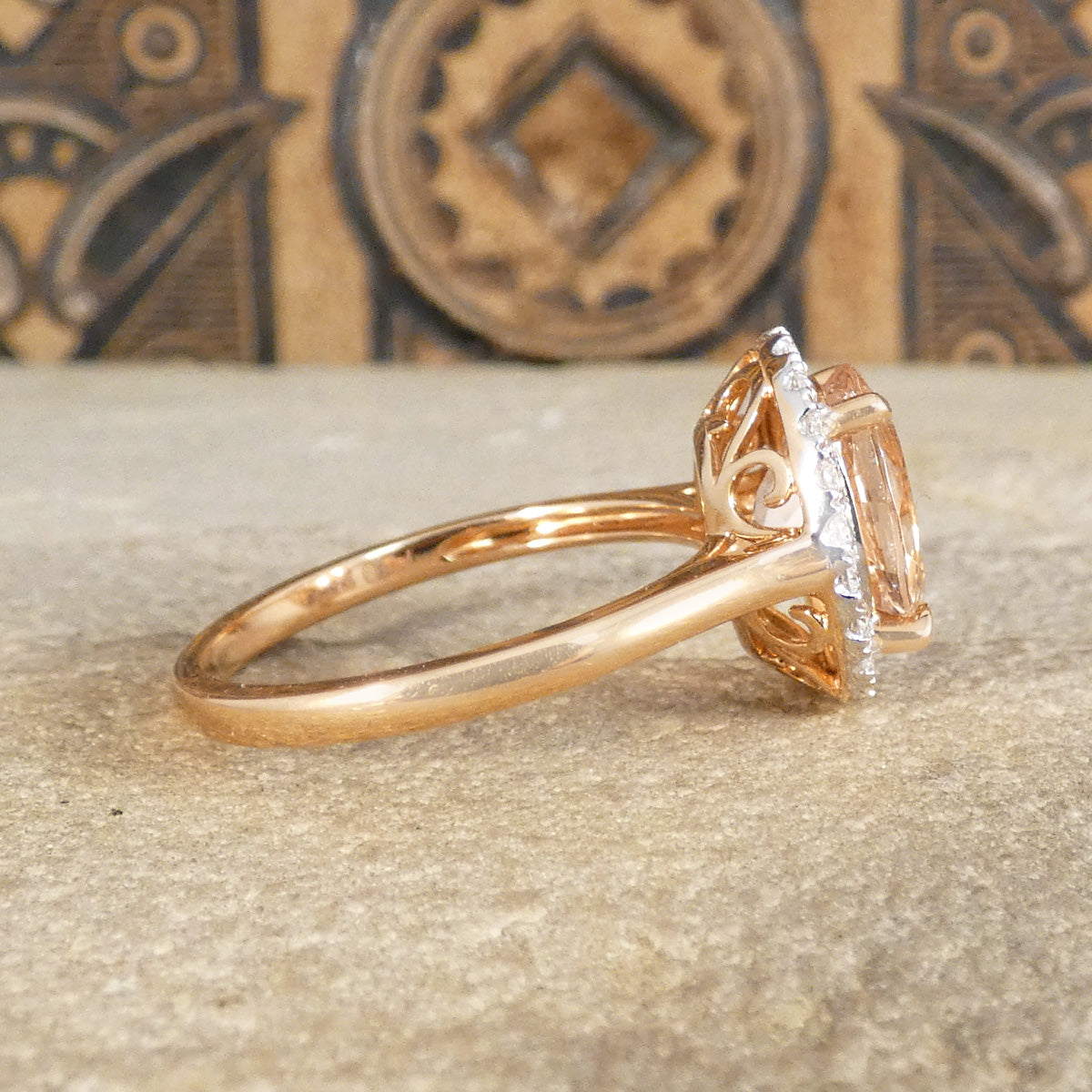 Side profile of Morganite and Diamond cluster ring with a detailed basket setting in a warm Rose Gold and substantial band.