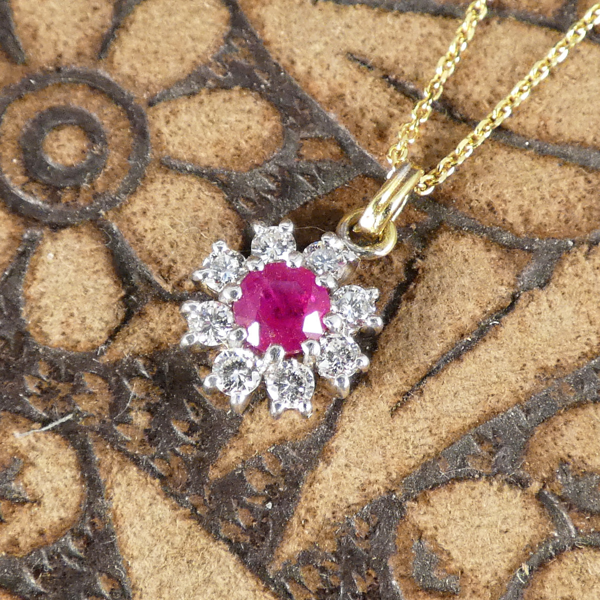 Ruby and Diamond Flower Cluster Pendant Necklace in 18ct Yellow and White Gold. The ruby is showing a bright and pinkish hue.