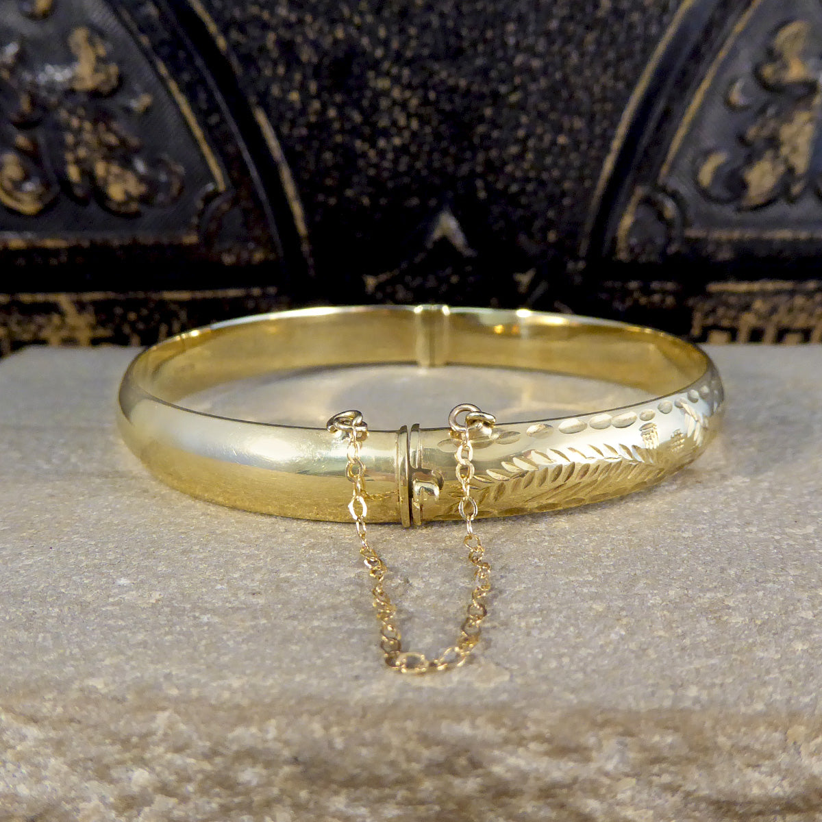 Gold bangle with safety shop chain