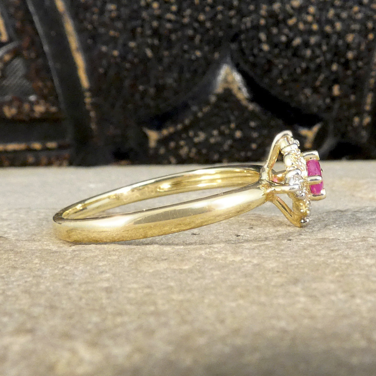 Side view of Ruby and Diamond Cross Section Illusion Set Ring in Yellow and White Gold showing a bright pink hue in the ruby and a gold cluster ring with a difference. 