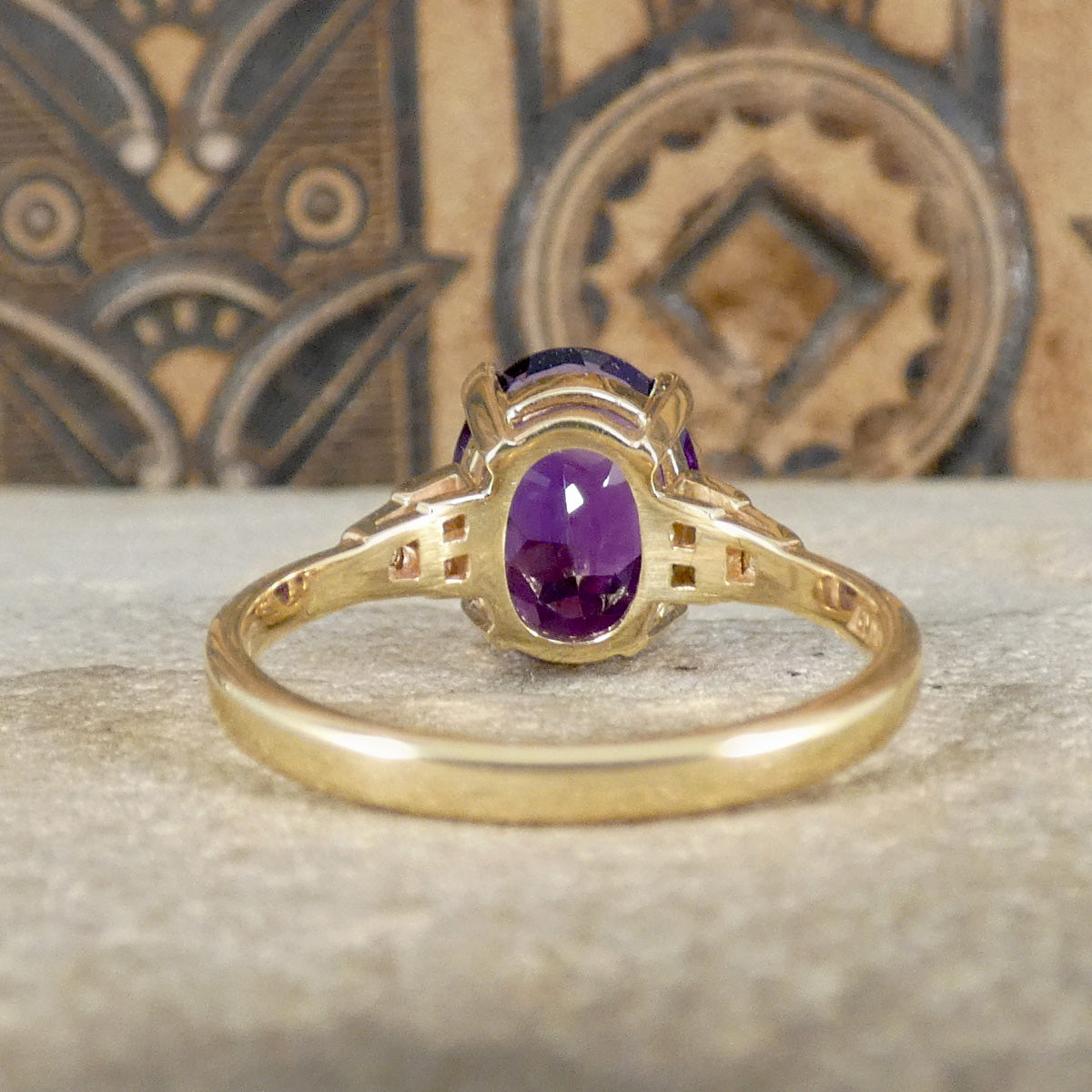 Back view of amethyst ring in a four claw setting with diamond set shoulders in 9ct yellow gold.