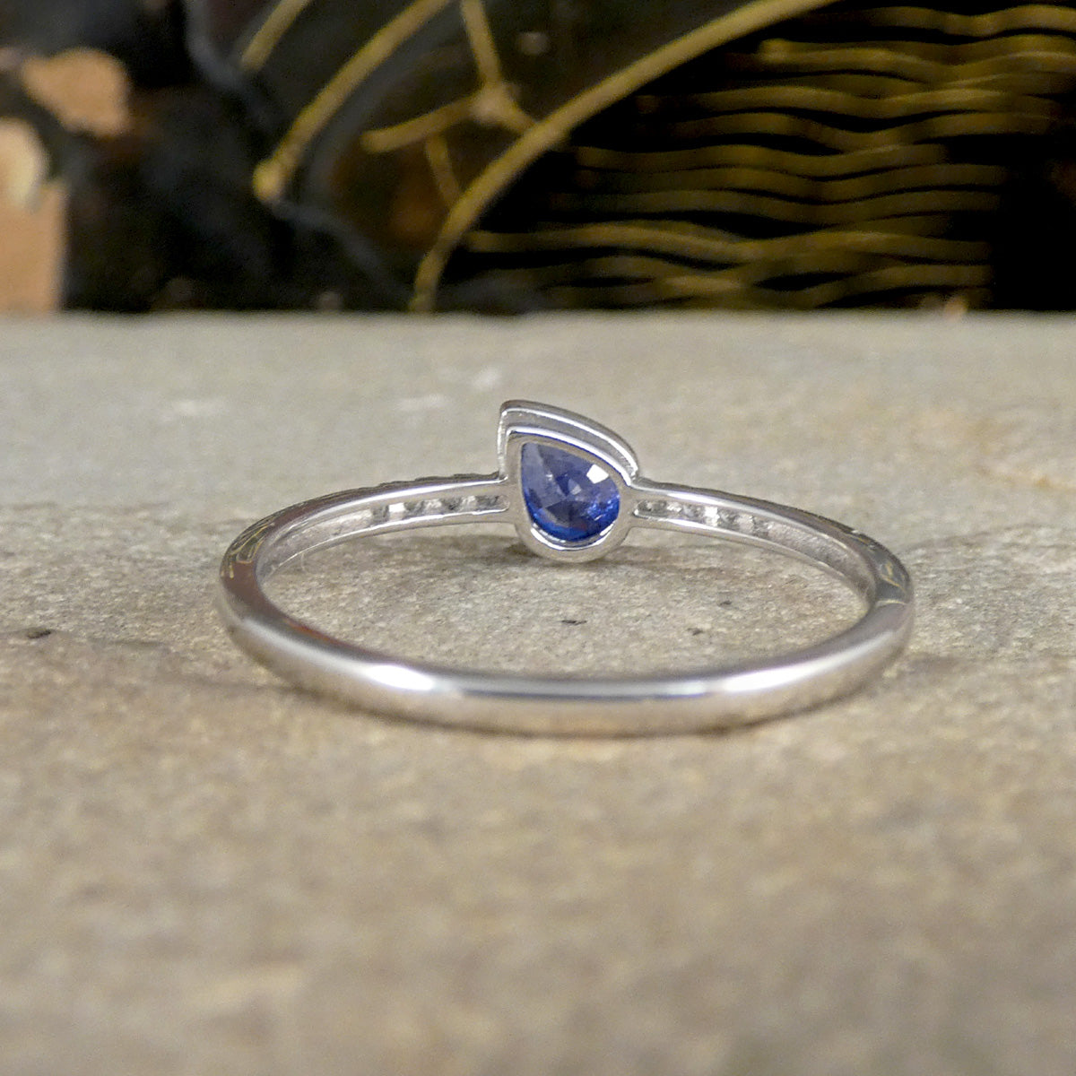 Sapphire and diamond ring shown from behind to see the setting and hollow set shoulders, highlighting why there is no ring resizing options.