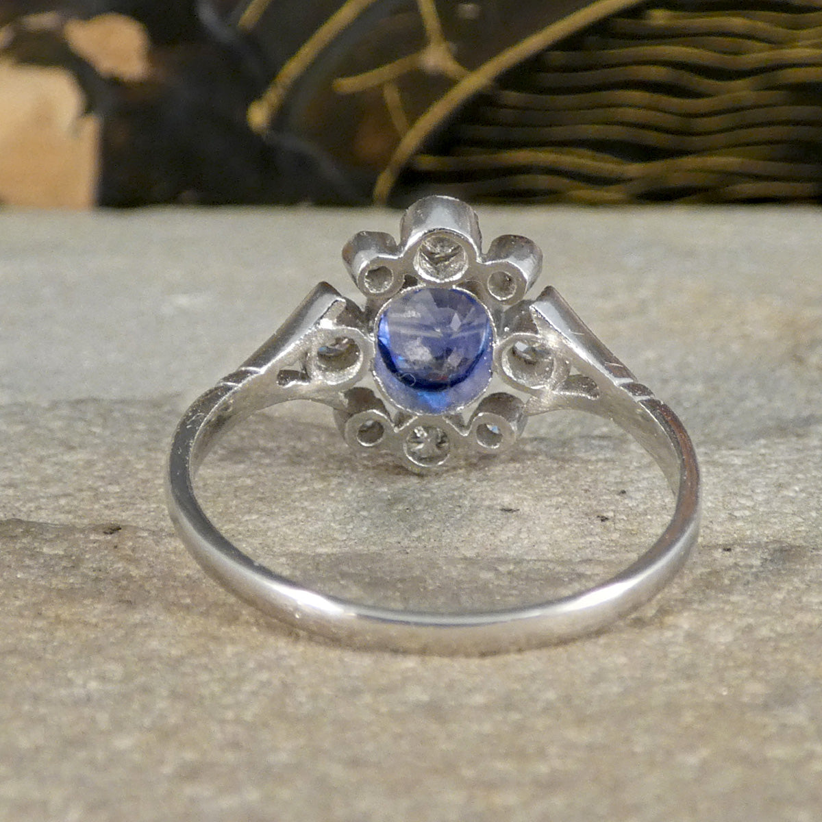 Rear view of a Sapphire and Diamond ring in platinum, highlighting the intricate openwork in the setting and the unique design of the central sapphire surrounded by diamond accents, emphasising its timeless elegance.