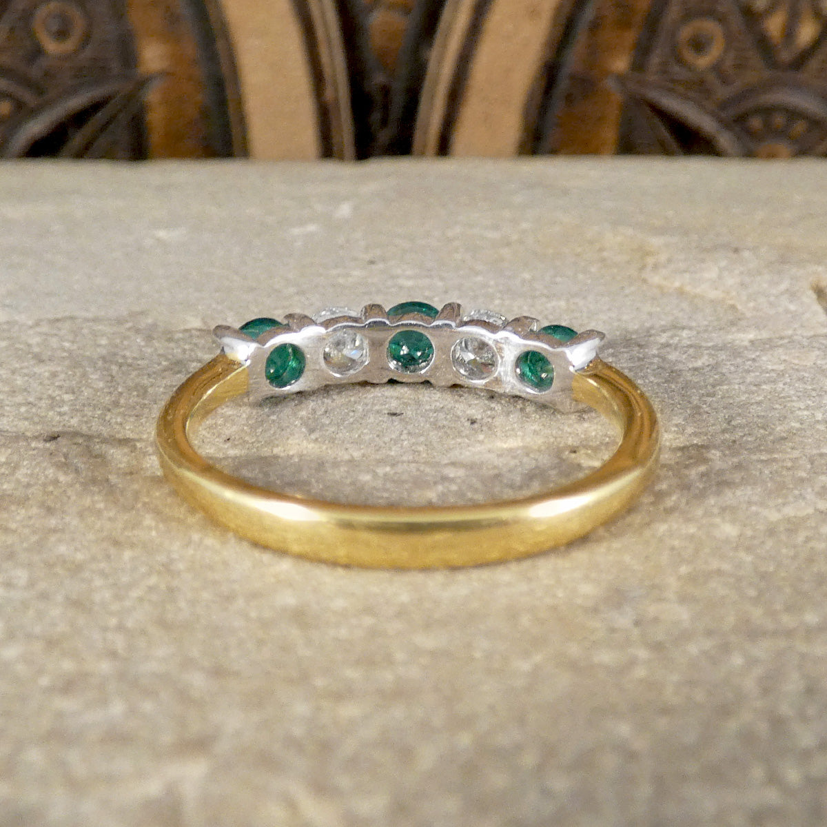 Back view of Emerald and Diamond five stone ring, with open back setting allowing light to pass through the stones, showing secure setting.