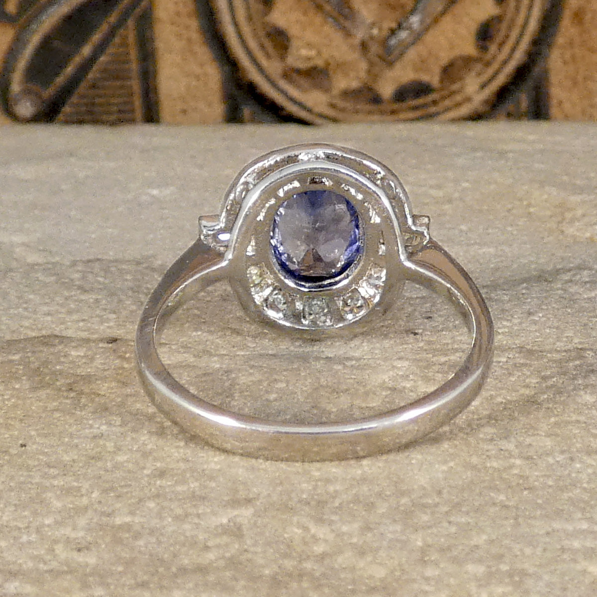 Back view of art deco style sapphire and diamond cluster ring in platinum, showing open setting allowing lots of light to dance through the stones.