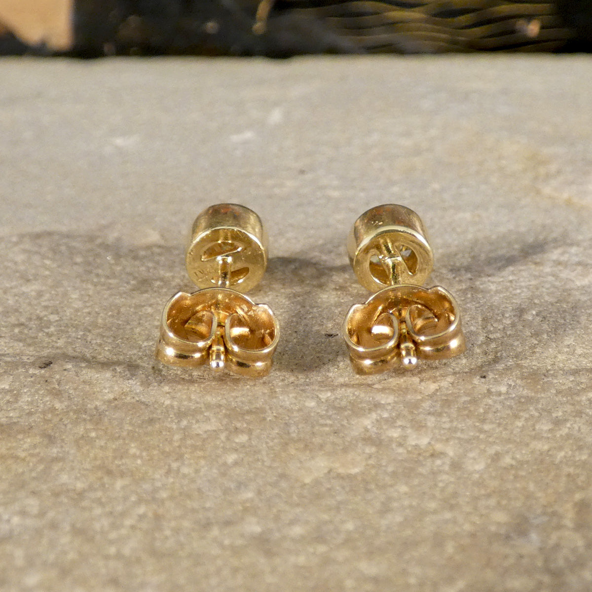 Back view of 0.40ct brilliant-cut diamond stud earrings in yellow gold bezel settings, highlighting butterfly backs for secure fastening and a polished finish.