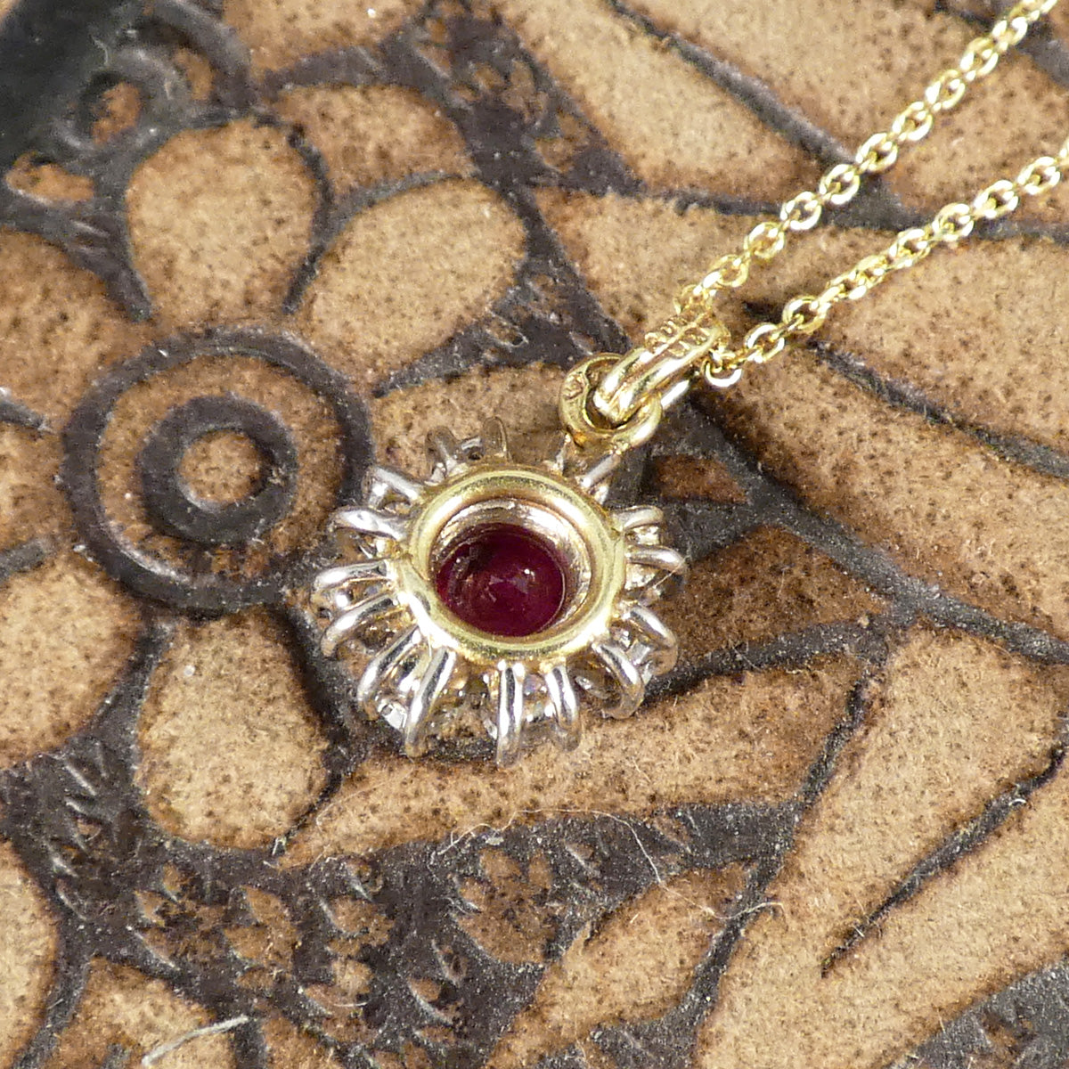 Back view of a Ruby and Diamond cluster pendant showing the open setting allowing lots of light to pass through.