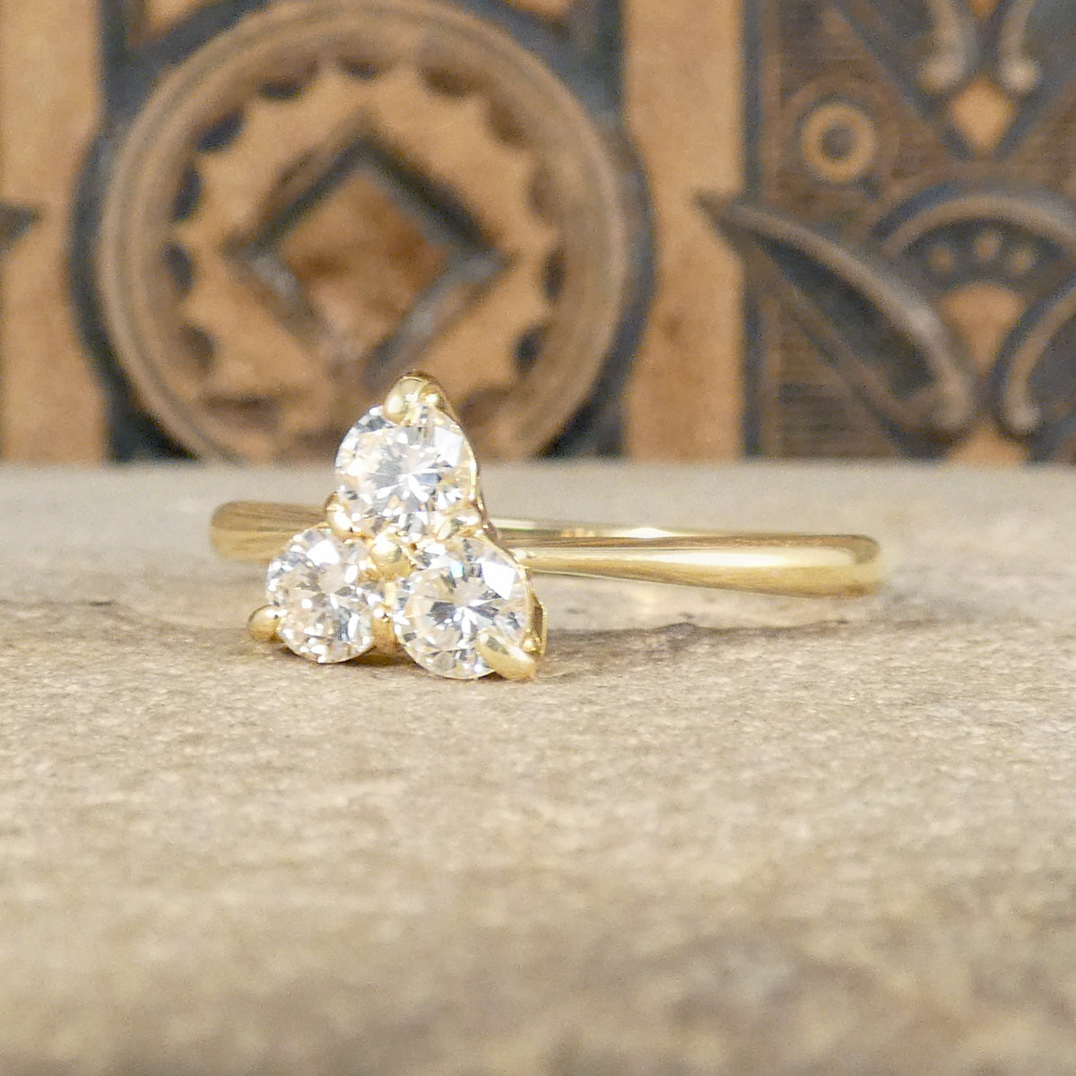 Elegant ring in 18ct yellow gold, featuring a sparkling three-stone diamond cluster design for a timeless and sophisticated look. The perfect gift or engagement ring idea.