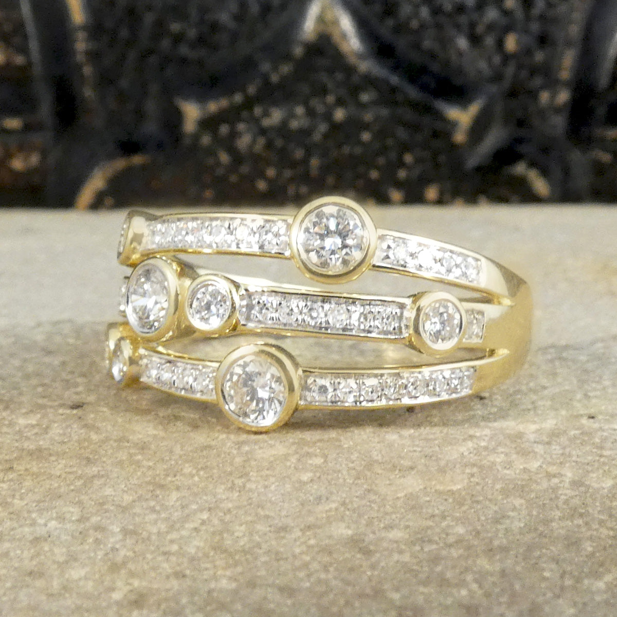 A modern bubble style diamond set ring. With larger and smaller Diamonds bezel set into three bands across a the head of the ring. A great gift idea and statement ring. All fully made in 9ct Yellow Gold with a warm beautiful aesthetic. 