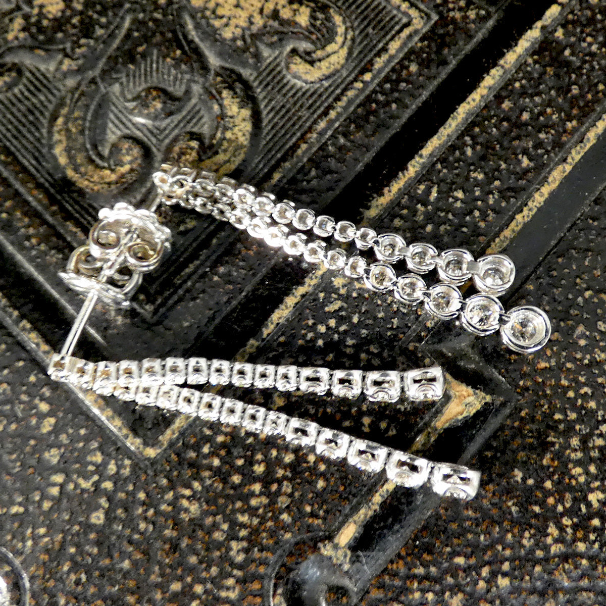 Elegant diamond drop earrings featuring independently dangling diamonds with a total carat weight of 1.13ct, set in 18ct white gold. Side and back profile to see settings and posts.