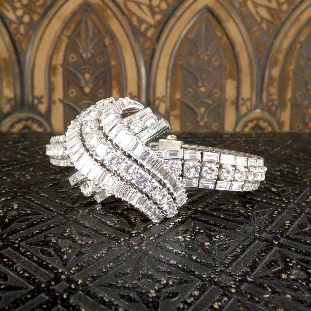 Side view of a stunning 1950's French diamond bracelet, featuring intricate detailing with approximately 30 carats of round and baguette-cut diamonds in a luxurious platinum setting.