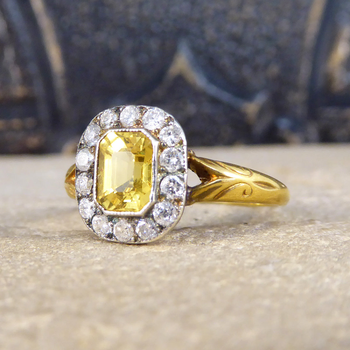 Emerald cut Yellow Sapphire in a full rub over collar setting with a slight milgrain edge.