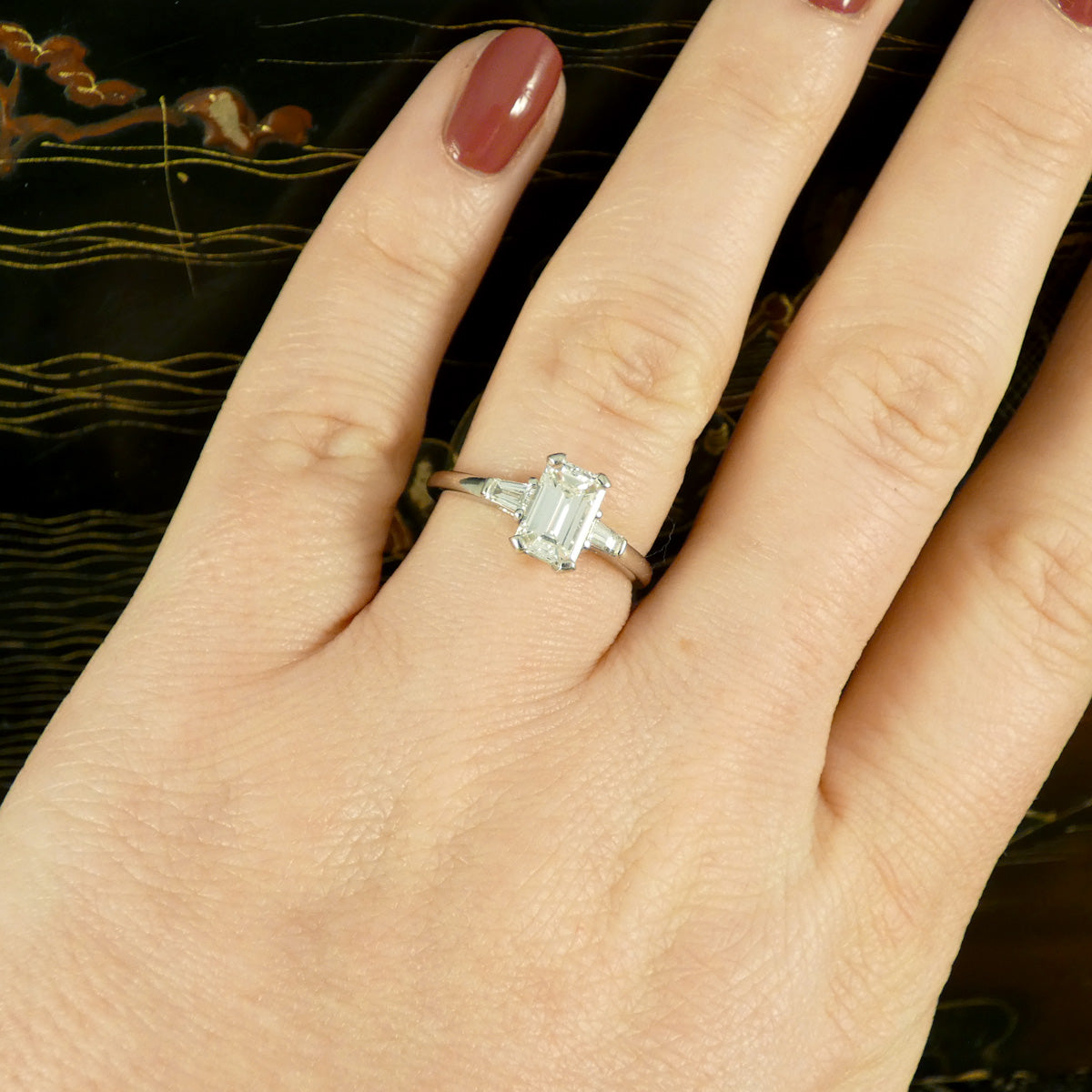 Emerald Cut Diamond Engagement Ring with Tapered Baguette Shoulders in Platinum. The perfect give and timeless ring. Shown on the finger to see how it will look worn on the ring finger.