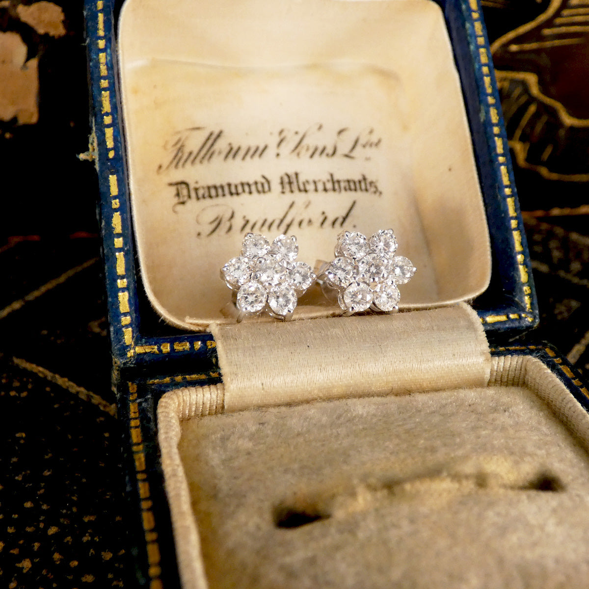 Daisy cluster earrings displayed in antique box.