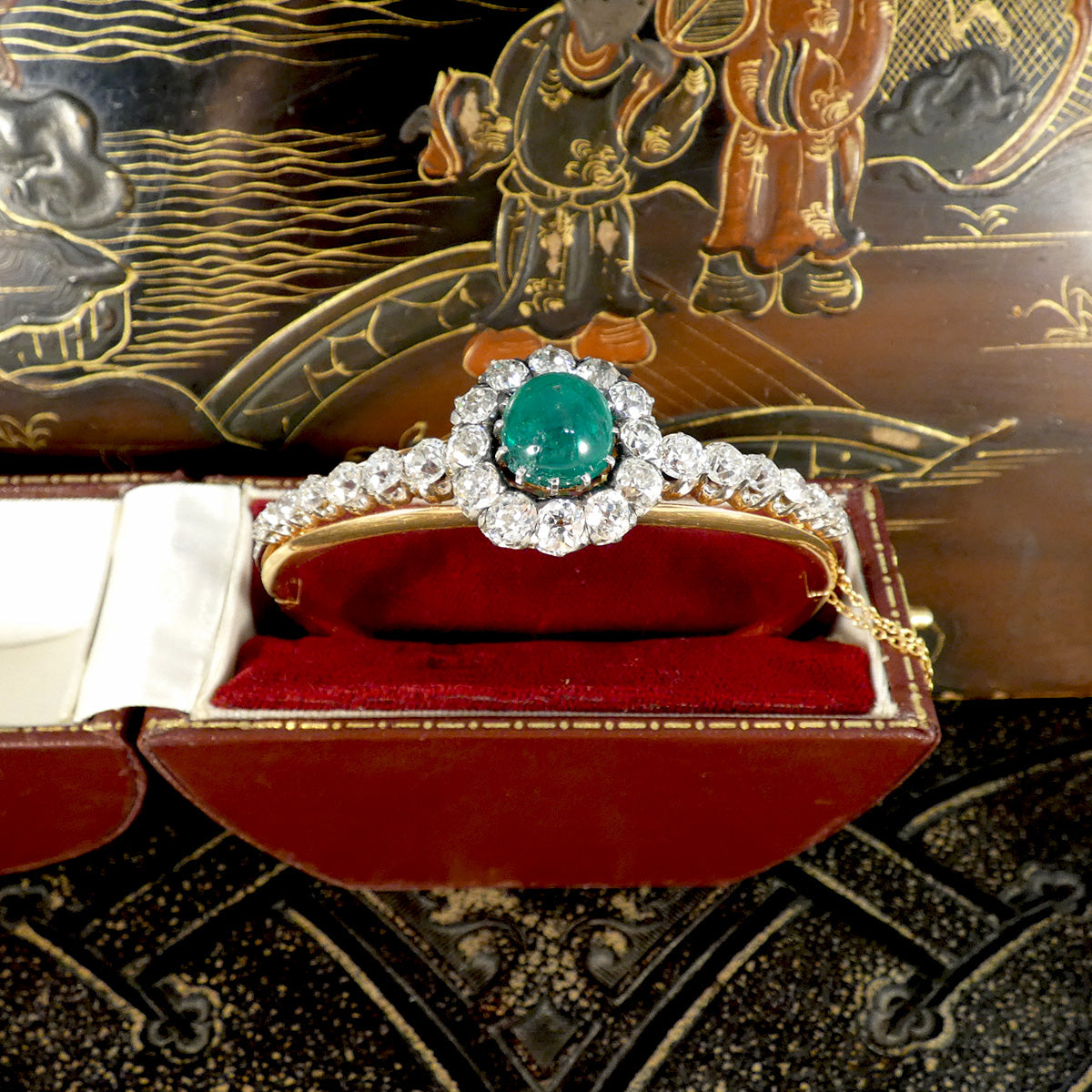 Exceptional late Victorian cabochon emerald and diamond bangle presented in an elegant antique red velvet box, showcasing its timeless beauty and remarkable craftsmanship, perfect for collectors of fine English jewellery