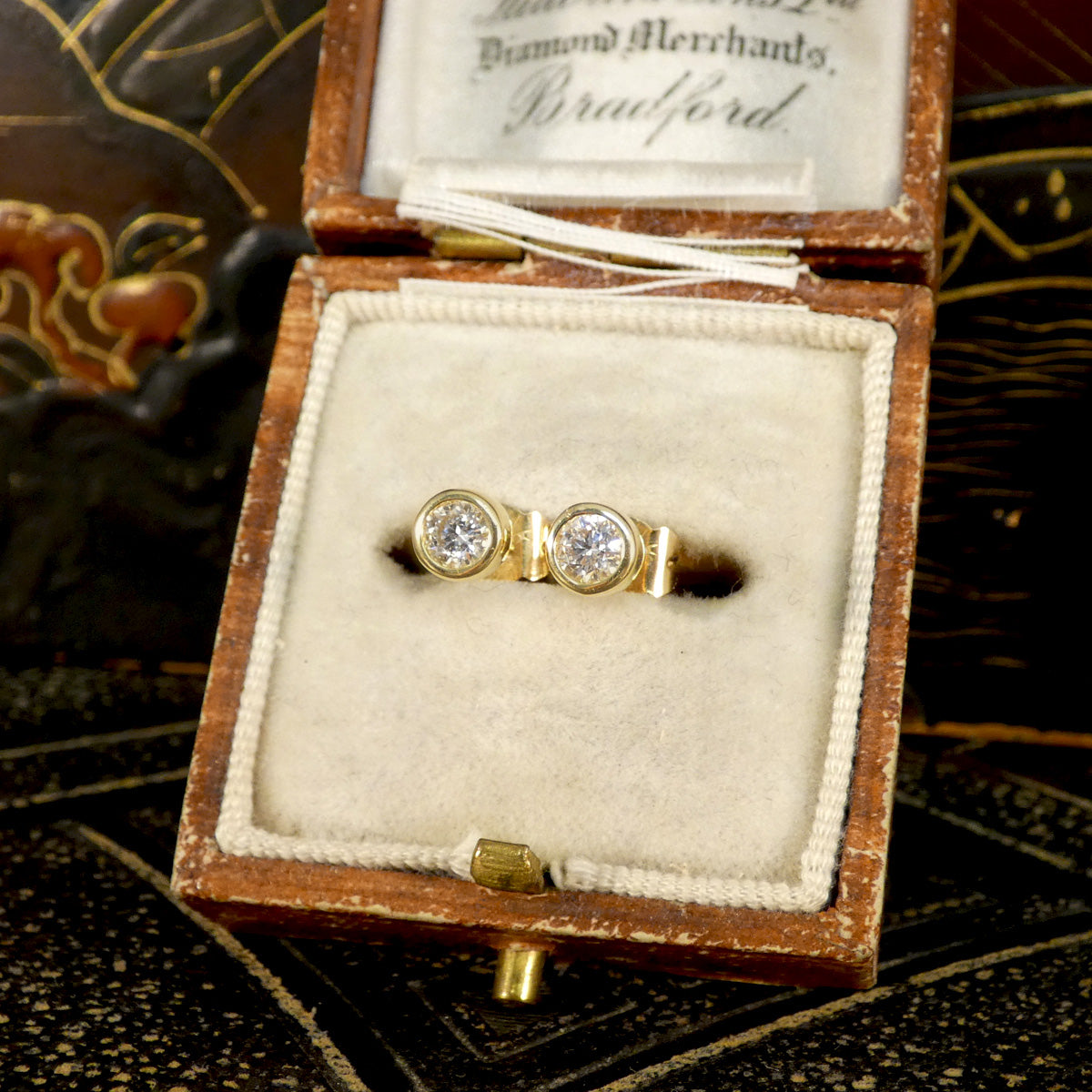 0.40ct brilliant-cut diamond stud earrings presented in a vintage jewellery box, highlighting their timeless bezel setting and yellow gold design.