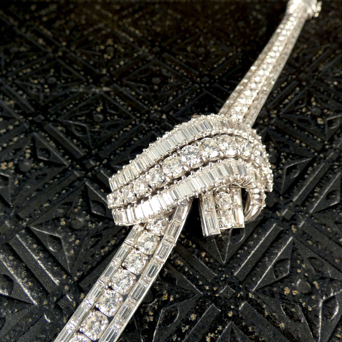 Elegant view of the 1950's French diamond bracelet laid flat, highlighting its flowing design with round and baguette-cut diamonds totalling approximately 30 carats.