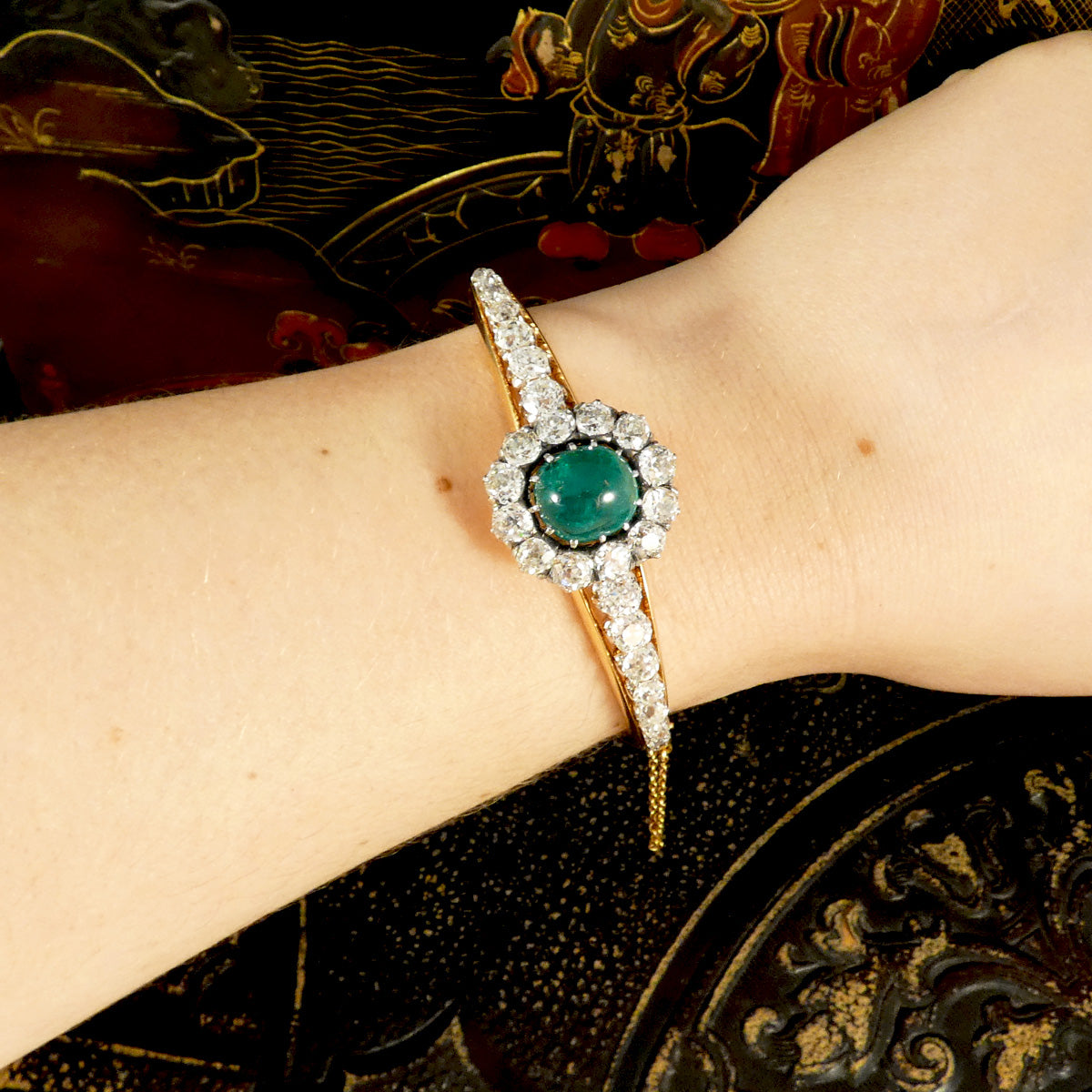 Late Victorian cabochon emerald and diamond bangle worn on the wrist, highlighting its graceful design and vintage elegance, a true statement piece for any jewellery connoisseur.