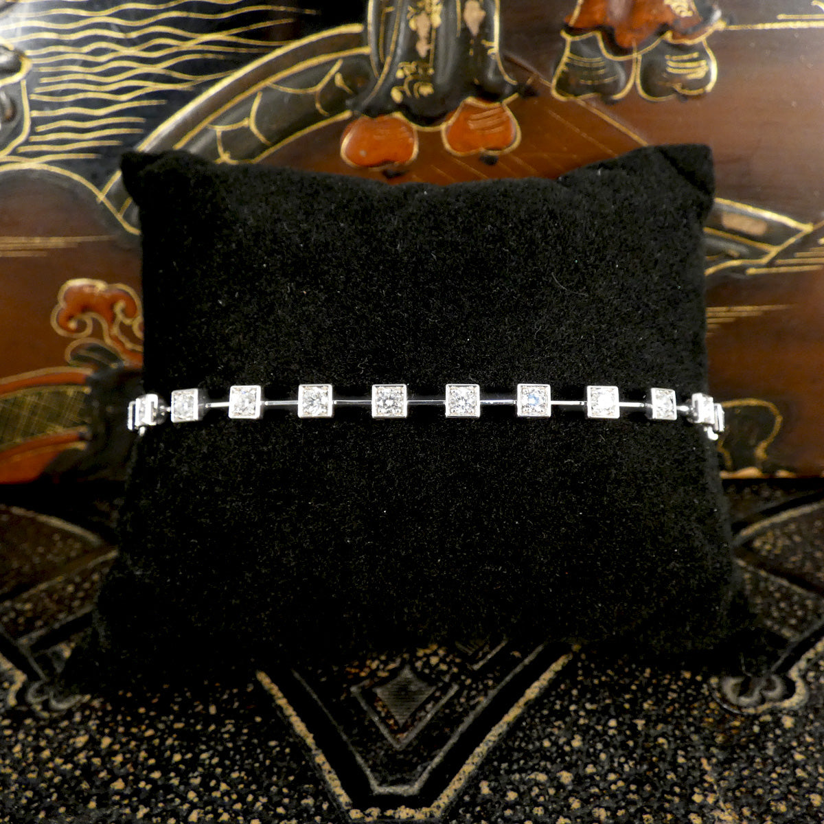 Elegant 18-carat white gold tennis bracelet featuring square bezel-set diamonds totalling 1.50 carats, displayed on a luxurious black cushion. The modern and refined design makes it a stunning statement piece for any occasion.