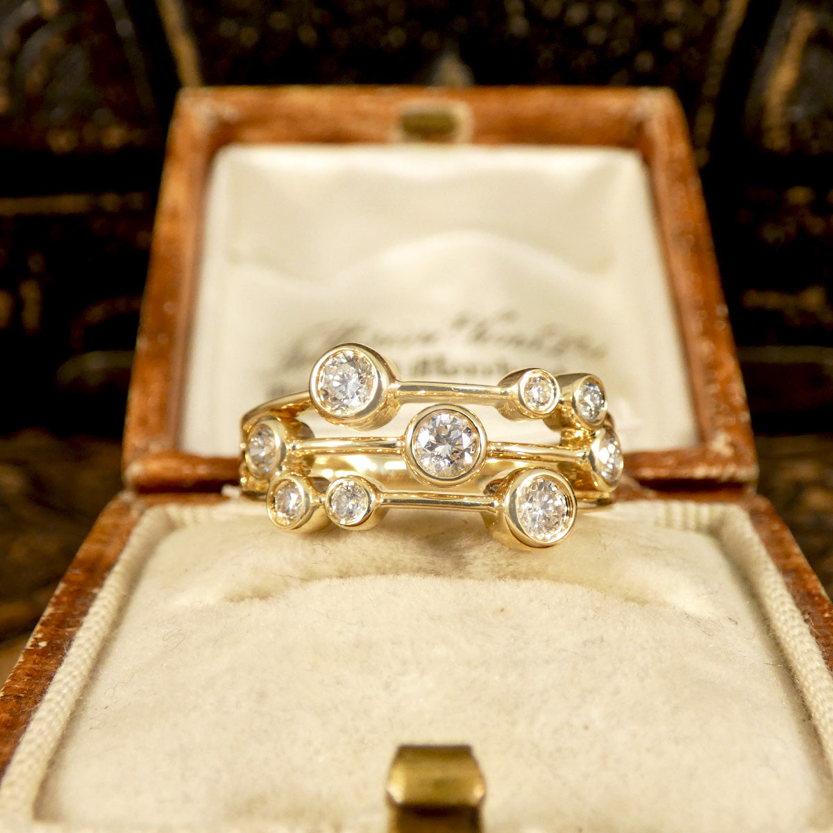 Side profile of Modern Diamond Set Bubble Style Ring in 14ct Yellow Gold with rub over collar settings and bright white sparkly diamonds set on three strands and all individually set. Displayed in vintage box.