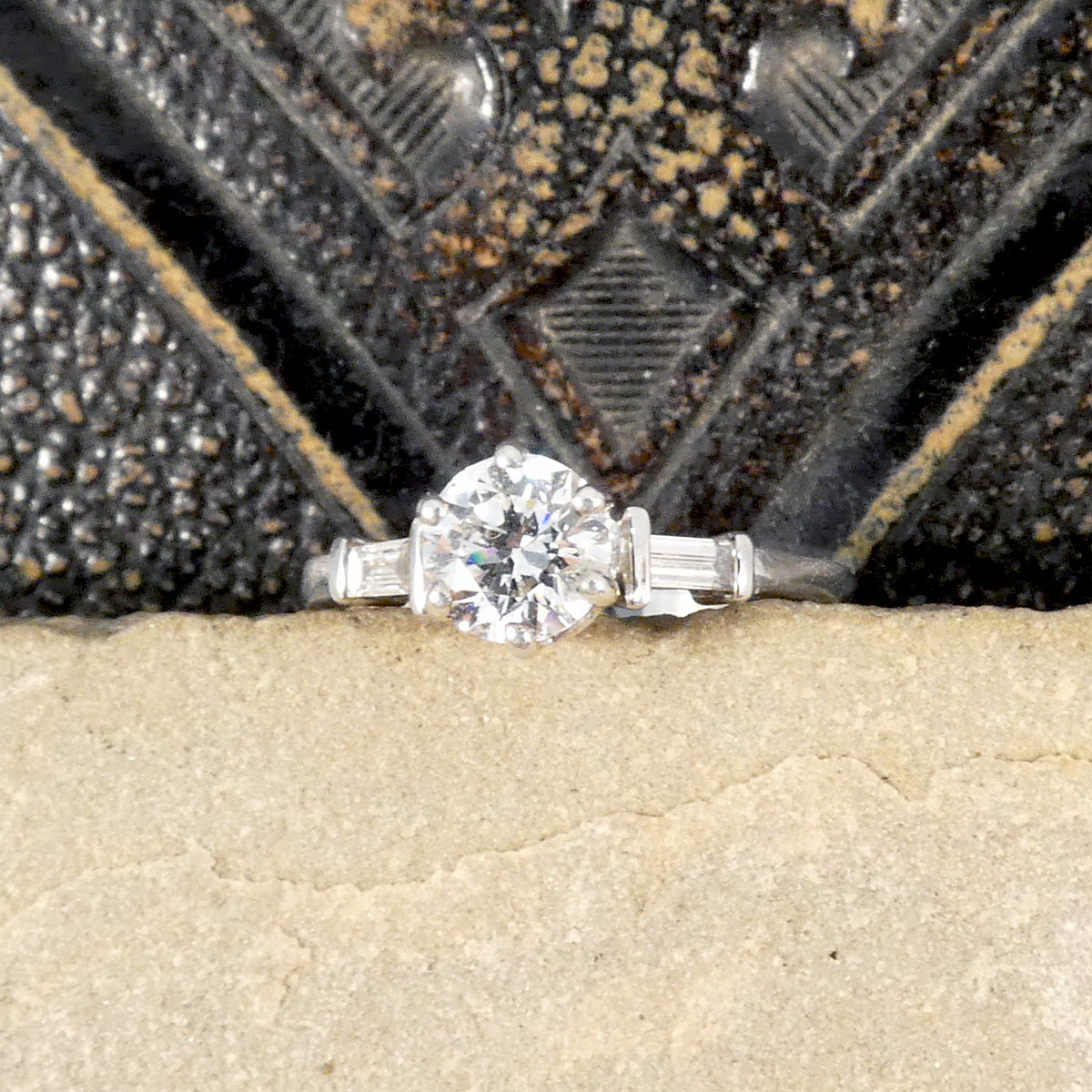 A classic brilliant cut diamond solitaire with baguette cut diamond shoulders in 18ct white gold. GIA certed diamond in a six claw setting, the perfect engagement ring.