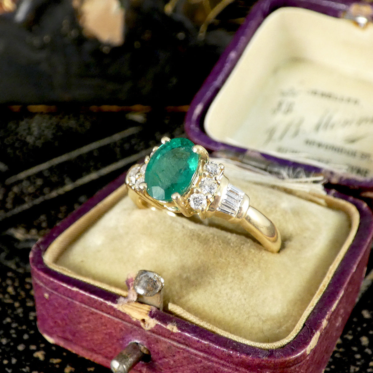 Vintage Emerald ring ith Brilliant and Baguette cut shoulders in a warm 14t Yellow Gold.