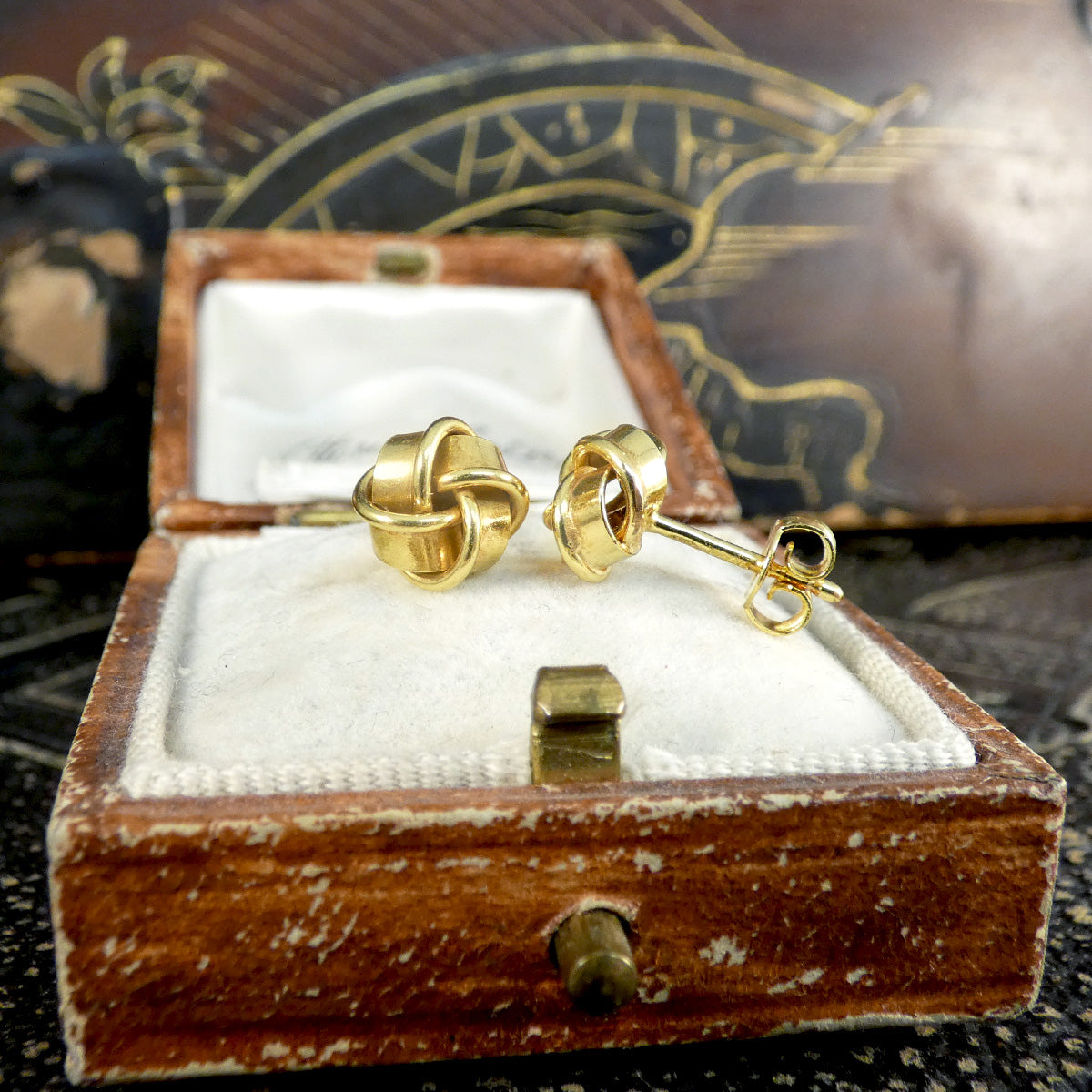 9ct yellow gold vintage knot earrings displayed in a detailed wooden jewellery box, showcasing their exquisite craftsmanship and secure post-back design.