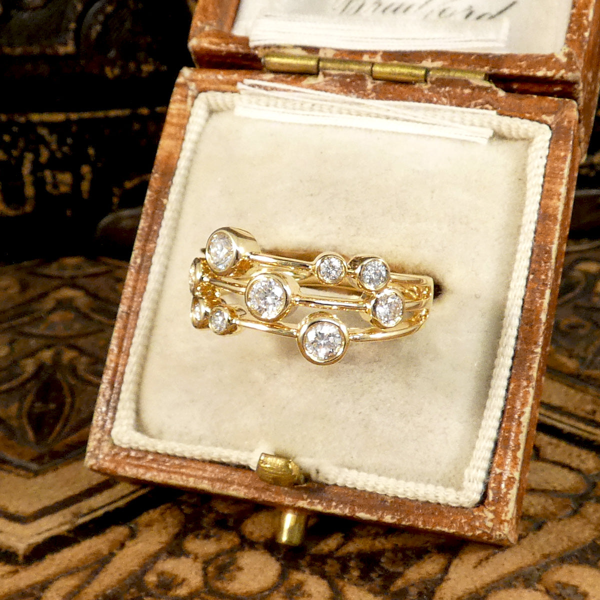 Side profile of Modern Diamond Set Bubble Style Ring in 14ct Yellow Gold with rub over collar settings and bright white sparkly diamonds set on three strands and all individually set. Displayed in vintage box.