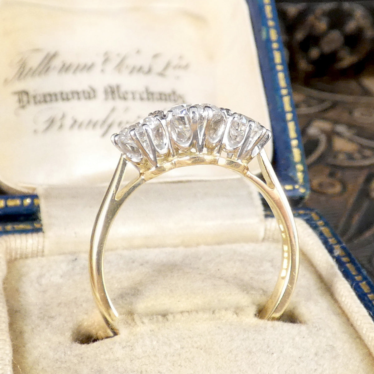 Side view of classic and elegant settings on three stone diamond ring.