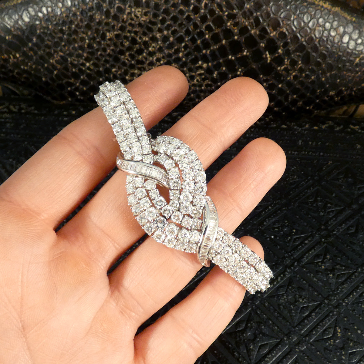 Vintage 1960s diamond bracelet featuring over 20ct of dazzling diamonds, intricately set in a knot design with exceptional craftsmanship in 18ct white gold. Shown on hand to display size ratio.